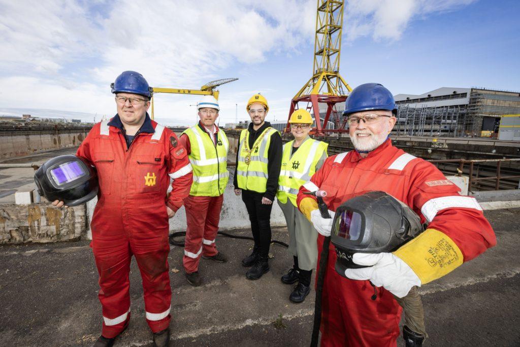Harland and Wolff employees Stephen Campbell (left) and Gary Davison (right) join the Lord Mayor of Belfast, Councillor Micky Murray, Jamie Rigby, Operations Manager, and Clare Caulfield, Project Manager from Skills with Unite the Union, at the world-famous shipyard. The welders have received support to develop their skills through a partnership between Belfast City Council, Unite the Union and the yard’s owners Navantia UK. The upskilling programme has helped retain welding skills at the yard and is one of a number of employability initiatives underway across the city, funded by the council, to support skills development.