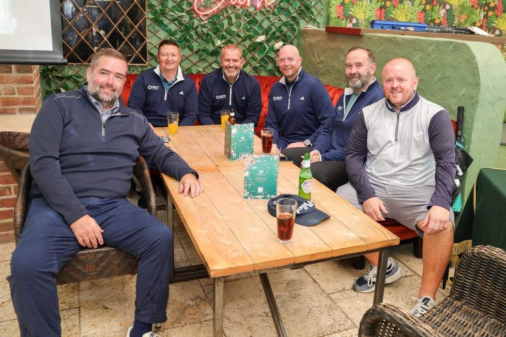 six people sat at a table in the Barn bar with drinks post-golf.
