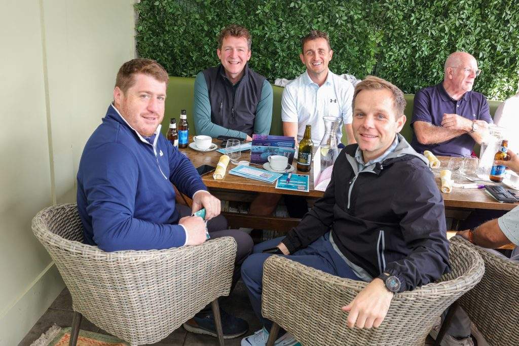 five people say around a table smiling in the galgorm restaurant 