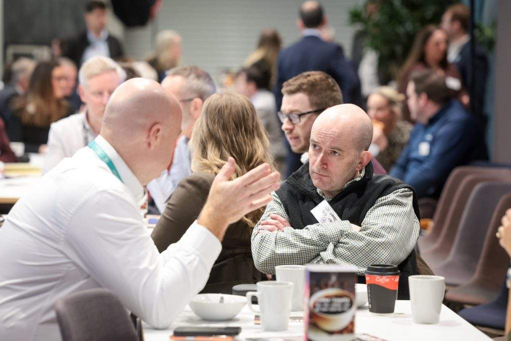 Attendees speak with each other during a networking break.