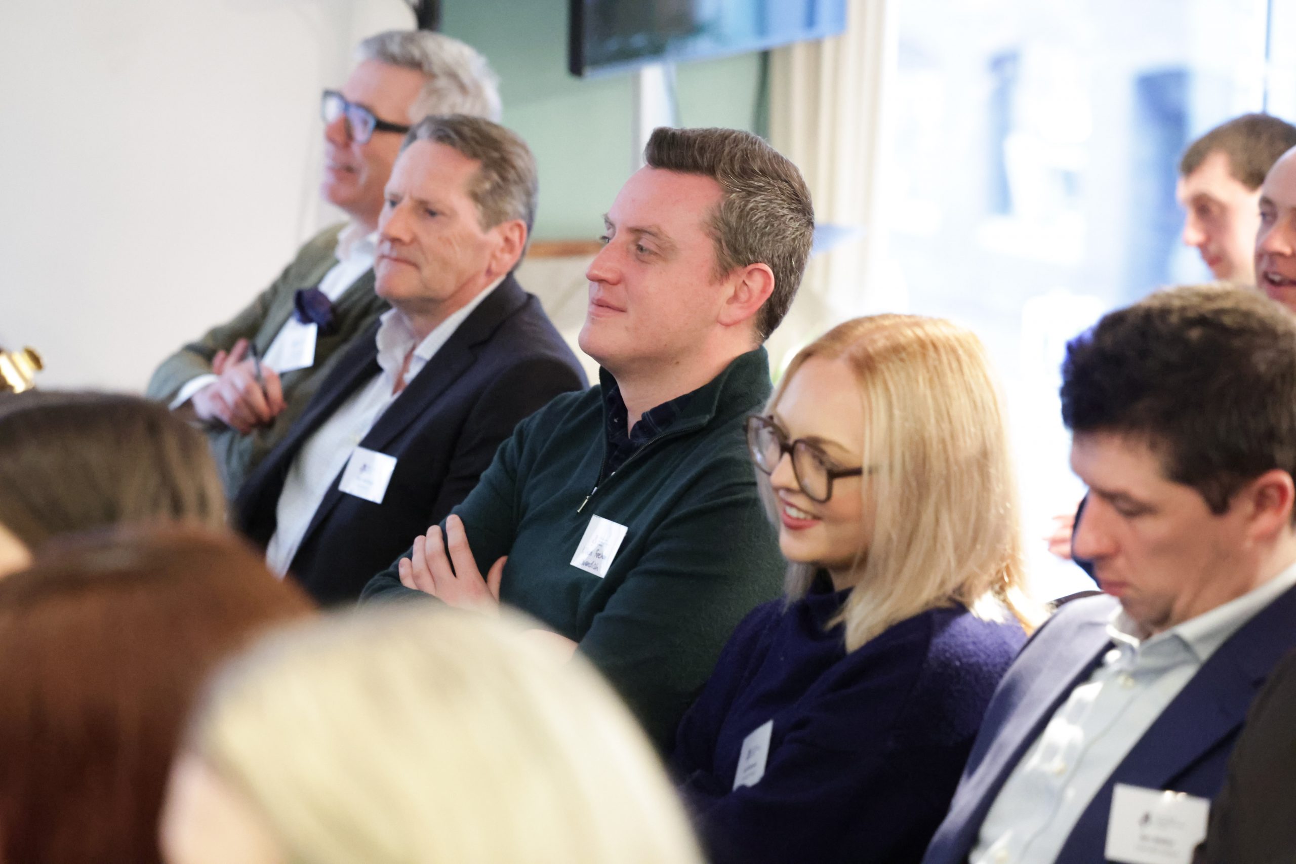 A group of attendees seated closely together, watching the event attentively.