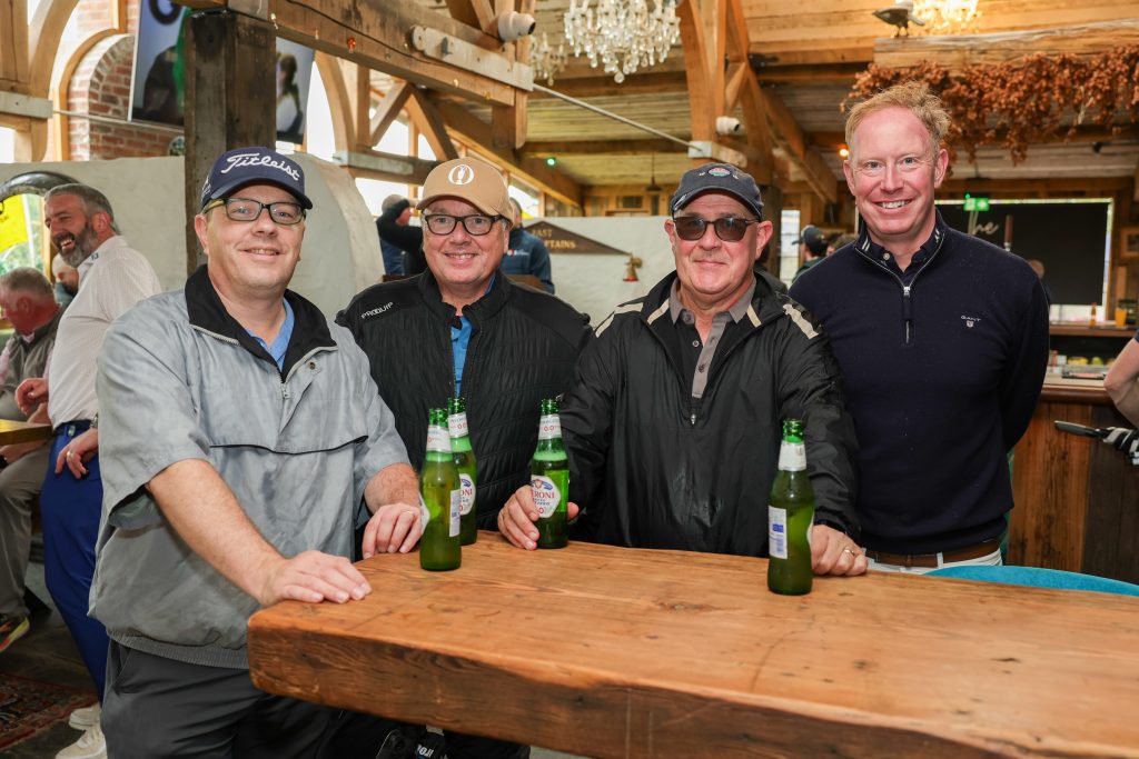 Four people standing with beers after the golf - in the Barn bar