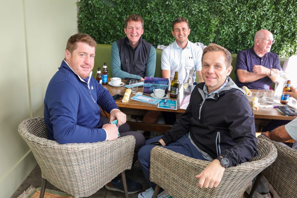 five people say around a table smiling in the galgorm restaurant 