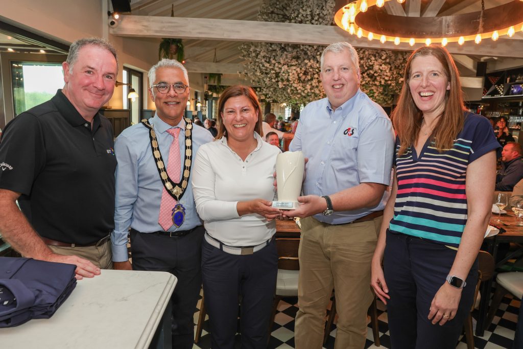 G4S's Kevin Scruby and NI Chamber President, Kailash Chada, standing with three prize winners smiling at the camera