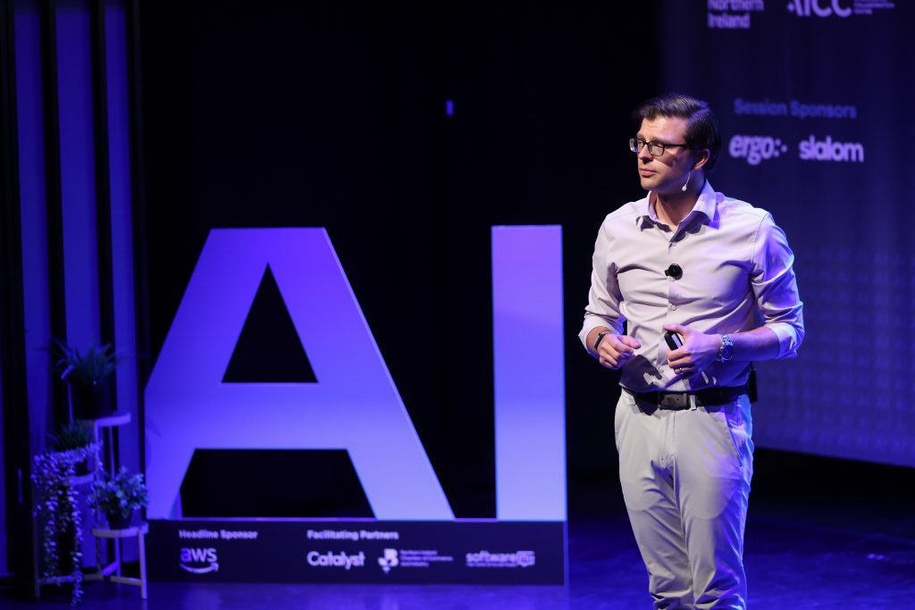 paul cheek on stage with a large AI cutout to the left