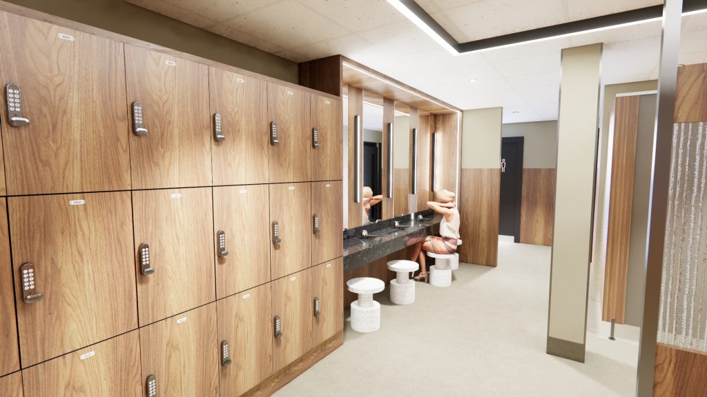new changing rooms showing wooden lockers, seats in front of a mirror and a person sitting at the mirror