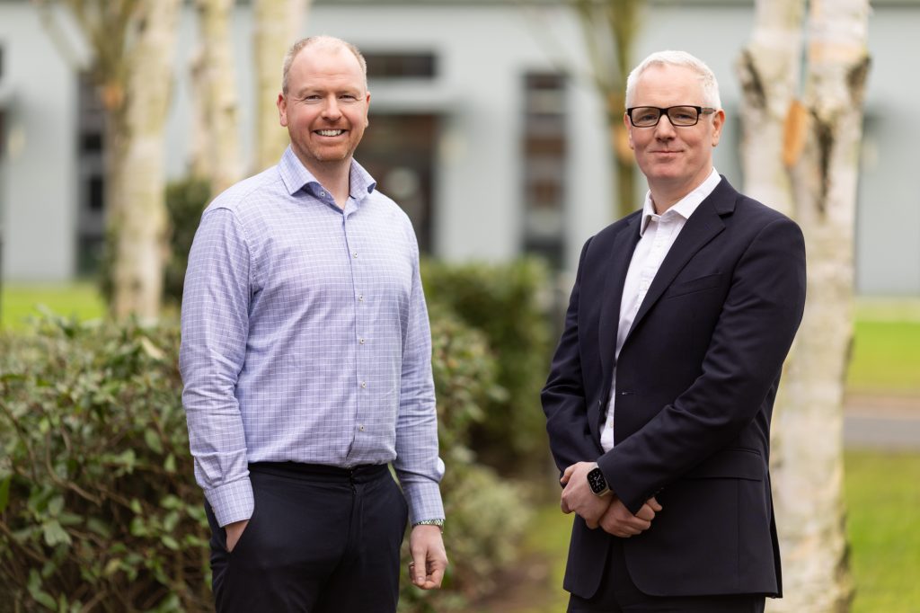 Two men standing in front of a building