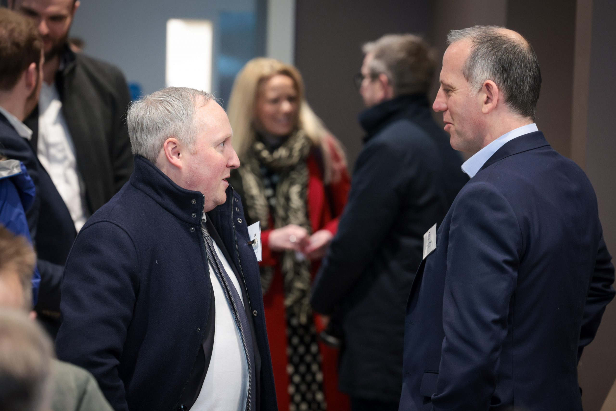 People talk together at a busy networking session.