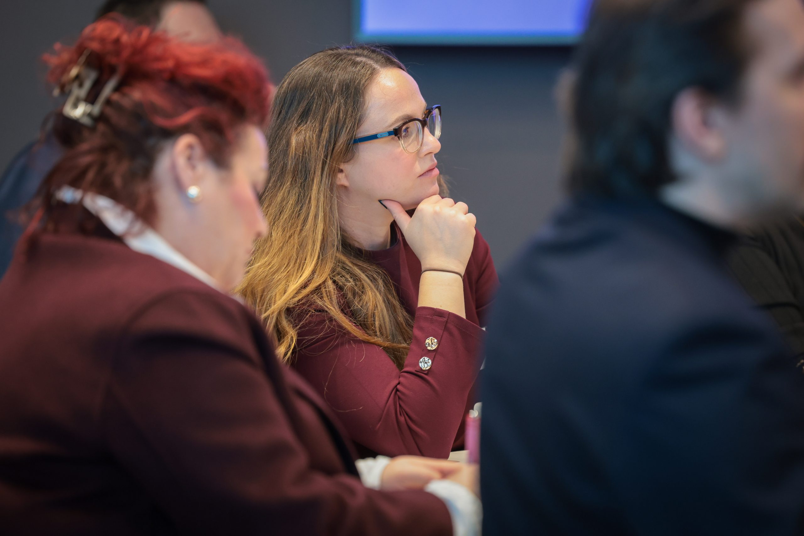 A woman listens attentively during a presentation.