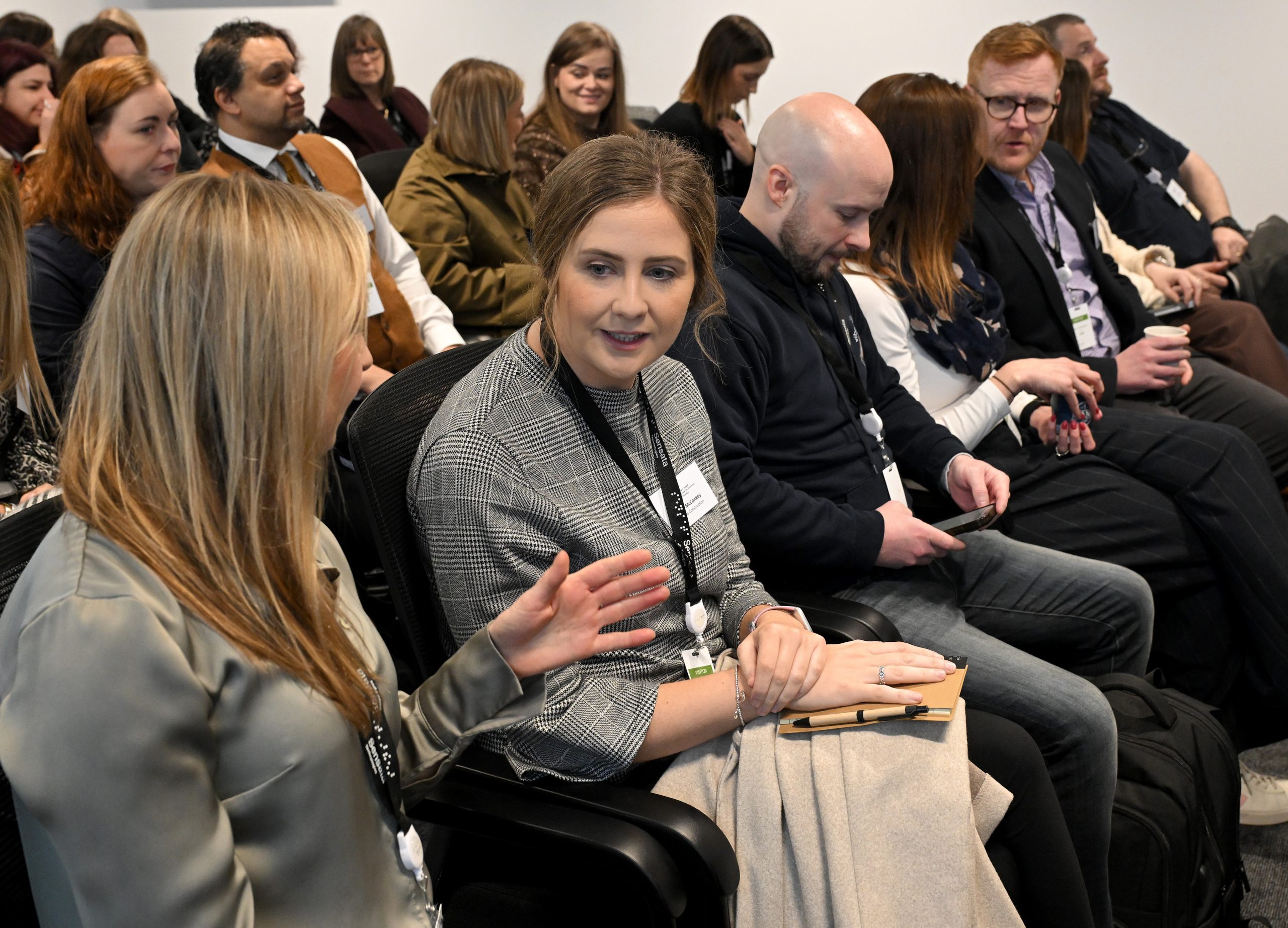 Audience members engage in discussion during an interactive session, with one person gesturing as they speak.